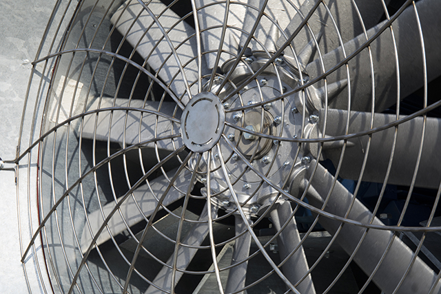 Close view of a large galvanised ventilation fan and its wire guard
